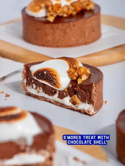 A cross-section of the S'mores Tart, revealing the layers of chocolate shell, ganache, and marshmallow.