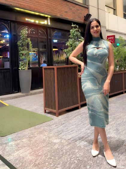 A stylish look in a modern, patterned midi dress, perfect for a casual evening out or a lifestyle brand shoot.