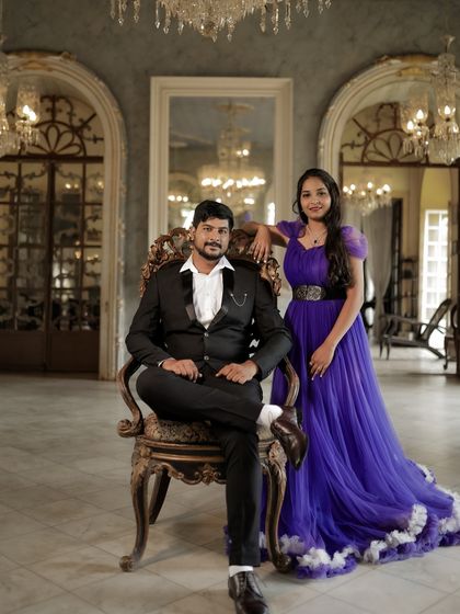 A regal and posed pre-wedding portrait. The couple looks like royalty in this grand setting, with the purple gown adding to the luxurious feel.