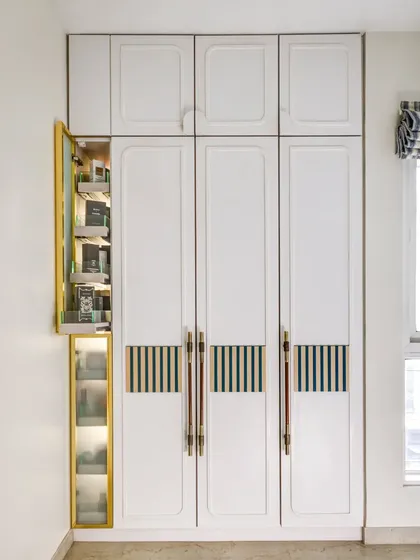 This custom wardrobe features a unique pull-out pantry for storing accessories. It's a clever, space-saving solution that is both functional and beautiful.