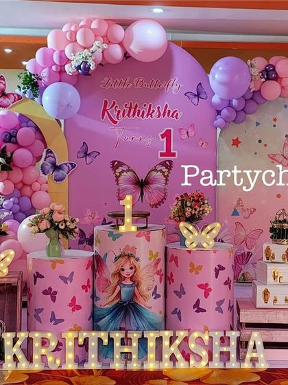 A close-up of the butterfly-themed stage, highlighting the detailed props and balloon work.