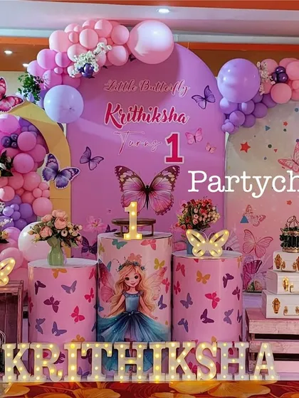 A close-up of the butterfly-themed stage, highlighting the detailed props and balloon work.