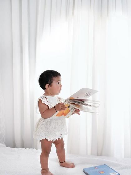 Reading little stories of life, one book at a time. This high-key, minimalist photo captures a child's curiosity in a beautiful and artistic way.