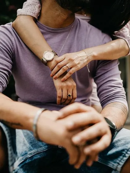 A close-up detail shot focusing on the couple's embrace and intertwined hands. Sometimes the smallest details tell the biggest story of love and connection.