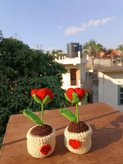 Two potted red tulips with little hearts stitched onto the pots, adding an extra touch of love.