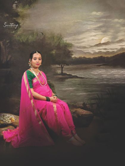 Inspired by the legendary artist Ravi Varma, this portrait captures the subject in a classic pink saree against a moody, painted landscape. It’s a beautiful fusion of fine art and the personal story of motherhood.