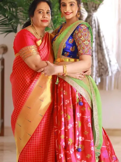 This mother-daughter duo showcases how coordinated outfits can celebrate individual style. I designed a vibrant half saree for the daughter with intricate aari work on the blouse, which beautifully complements her mother's classic silk saree, creating a stunning and connected look.