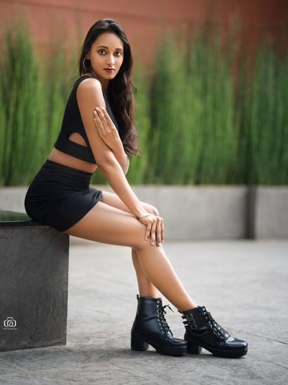 A similar pose from the urban architectural shoot, capturing a different expression. The minimalist background keeps the focus on the model and her contemporary look.
