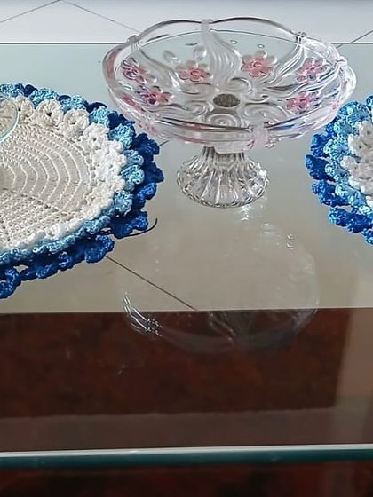 A set of two placemats with a beautiful blue floral border, shown here on a glass table. The design adds elegance without overwhelming the space.
