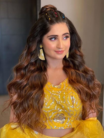 A braided half-tie open look with colorful threads woven in. This bohemian-inspired style is perfect for a fun and relaxed Mehendi party.