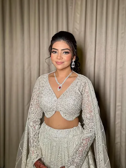 A stunning sangeet look for Ruchita that stole the spotlight. The makeup features a classic smokey eye and a nude lip, paired with a shimmering white lehenga.