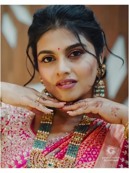 A playful and cute portrait of Varsha. Her soft makeup and romantic hairstyle make her look youthful and fresh, perfect for a day of celebration.