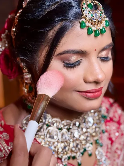 Another angle of the blush application, showing the soft, shimmery eyeshadow and the bride's relaxed expression.