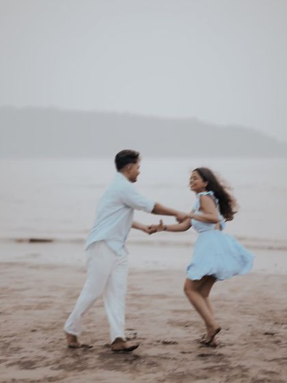 Capturing the pure joy of being together. This action shot of the couple dancing on the sand shows the fun and energy we can bring to your pre-wedding beach shoot.
