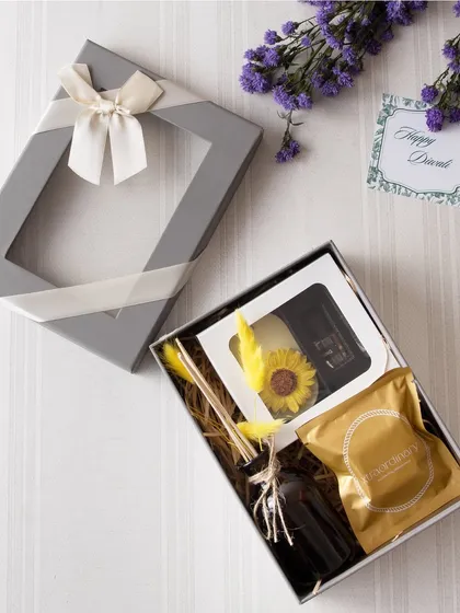 A simple yet elegant gift box featuring a diffuser, a candle, and a pack of our gourmet treats. The windowed box design gives a sneak peek of the goodness inside.