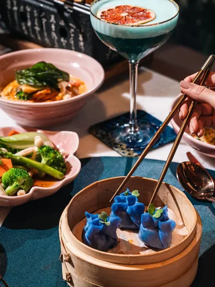 Journey to the East at Kokoon, our specialty Asian restaurant. Here, vibrant presentation meets bold flavors, as seen in our striking blue pea flower dim sum, part of a larger spread that promises an exciting and modern culinary adventure.