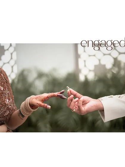 The symbolic exchange of rings during an engagement ceremony. This close-up shot focuses on the hands and the ring, a powerful and timeless image that marks the official start of a couple's journey together.