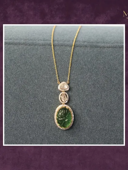 This pendant, featuring a carved green stone and two uncut diamonds on a simple gold chain, offers serene sophistication. It's a piece where subtle luxury meets refined style.