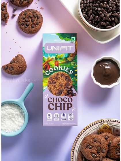 A top-down shot of a Unifit choco-chip cookie box, surrounded by its ingredients.