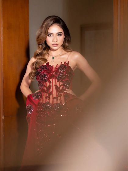 Presenting Rose. A stunning, deep red gown with a sheer corset and floral appliqué.