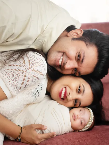 A creative and fun family pose, with everyone stacked up and smiling. This shows the playful and loving dynamic of this new family of three.