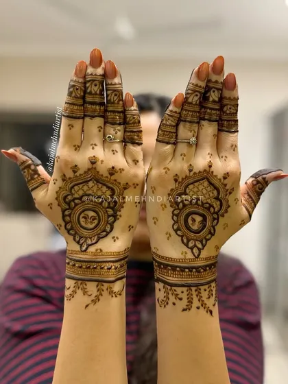 A fancy backhand design featuring a central mandala with a peacock motif, perfect for a bridesmaid or guest.