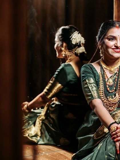 A reflection of beauty and grace. This artistic shot showcases the rich texture of the saree and the joy of the mother-to-be.