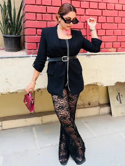 This outfit is a masterclass in tonal dressing. The black base is elevated with a wine-colored bag and a dusky pink choker, all from the same color family, creating a cohesive and stylish look.