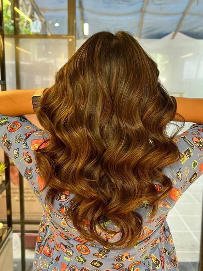 The final result of the caramel brown color, styled to perfection. The light reflects beautifully off the healthy, colored hair.