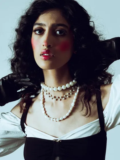 A closer crop on the dramatic makeup. This view shows the texture of the glossy lips and the placement of the vibrant red blush on the cheeks.