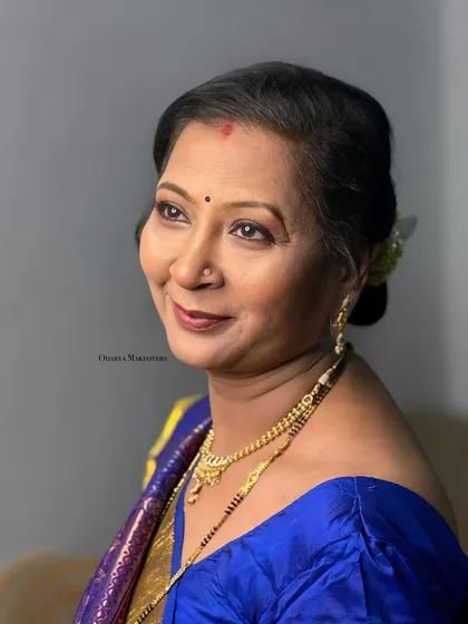 An elegant and graceful look for the bride's mother. The makeup is soft, and the hairstyle is a classic bun.