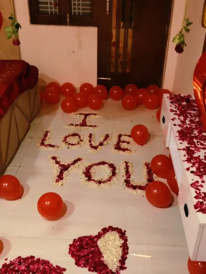 The floor of this romantic setup features 'I LOVE YOU' written with white and red rose petals, along with a petal heart. It's a classic and heartfelt gesture.