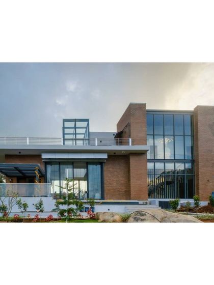 This is a duplicate of ID 83. An exterior view of the Nandi Hills residence, showcasing the interplay of solid brick masses and expansive glass walls.