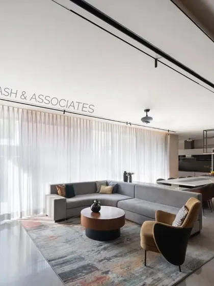 Clean, straight lines command the interiors of the family lounge, where warm wood tones are balanced by a bright, open kitchen area.