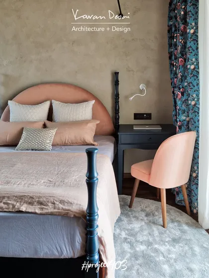 The master bedroom in the Red Fort Project features a custom four-poster bed and a blush pink headboard. The floral curtains add a touch of pattern and color to the otherwise soothing and neutral space.