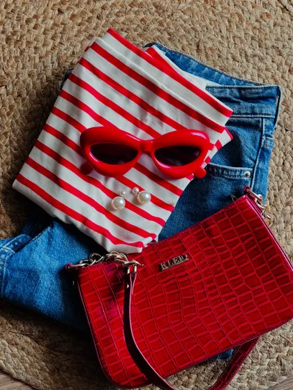 A real-life look at a Parisian-inspired outfit. The combination of a red-and-white striped top, classic denim, and bold red accessories creates a vibrant and cheerful look that's simple yet impactful.