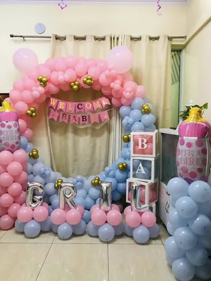 A "Welcome Baby" ring decoration in pink and blue, with the baby's name "GRIM" spelled out in silver foil balloons.
