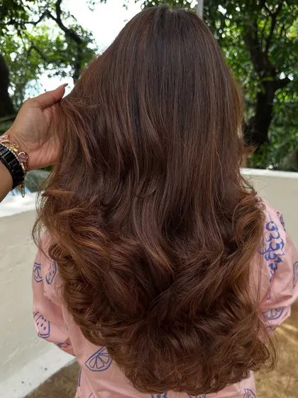 Nothing screams confidence like freshly colored hair. We went for a rich chocolate brown with subtle highlights, styled with big, bouncy waves for a glamorous finish.