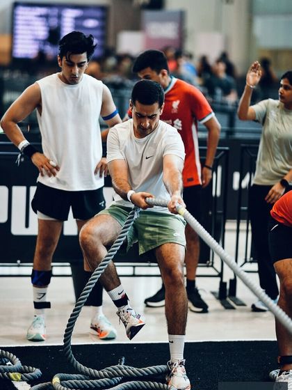 Teamwork makes the dream work. Two members of the crew tackle the rope pull station together, showing the power of partnership in a doubles competition.