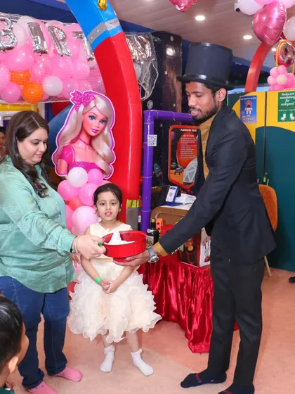 Even the magic show gets a themed touch. Here, the birthday girl participates in a trick at her fabulous Barbie party.