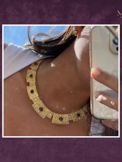 A touch of gold, a hint of grace. This client selfie shows our unique gold collar necklace with multi-colored gemstones, perfect for a modern, edgy look.