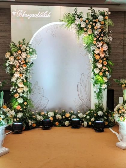 A beautiful photo booth backdrop with a custom hashtag and delicate floral illustrations. The asymmetrical arch of flowers provides a perfect frame for guests to capture memories of the special day.