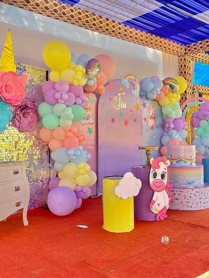 A different view of the unicorn stage, showing a sequin backdrop and a large unicorn head prop made of paper flowers.