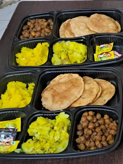 Celebrating a festival at home? Our packed thalis are the perfect solution. This Ganesh Chaturthi special meal includes puri, sukha kala chana, aloo sabzi, and halwa, all prepared without onion or garlic.
