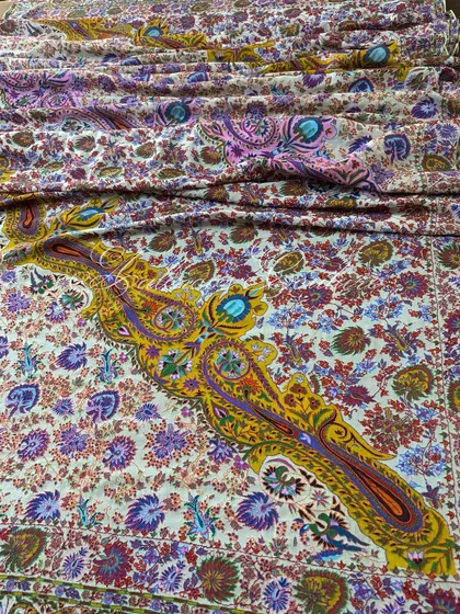 A wide shot capturing the magnificent spread of the Kashmiri Kalamkari dupatta, with its large, dramatic paisley motifs rendered in rich yellows and purples.