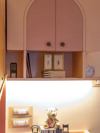 A look at the clever storage and display solutions in this kids' room. The overhead cabinets with arched doors and open shelving are perfect for keeping toys and treasures organized.