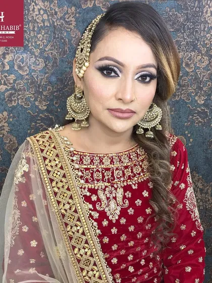 A detailed shot of a Muslim bridal look, focusing on the intricate eye makeup and traditional side jhoomar accessory.