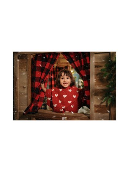 A joyful little girl peeks through the curtains of our rustic Christmas cabin.