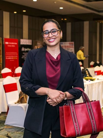 Ready for a corporate workshop in a classic black blazer and red top. My style is always professional, ensuring I represent the event's standard of excellence.