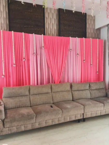 A simple and effective backdrop for a home function. I used pink drapes and hanging jasmine flower strings to create a designated photo area.